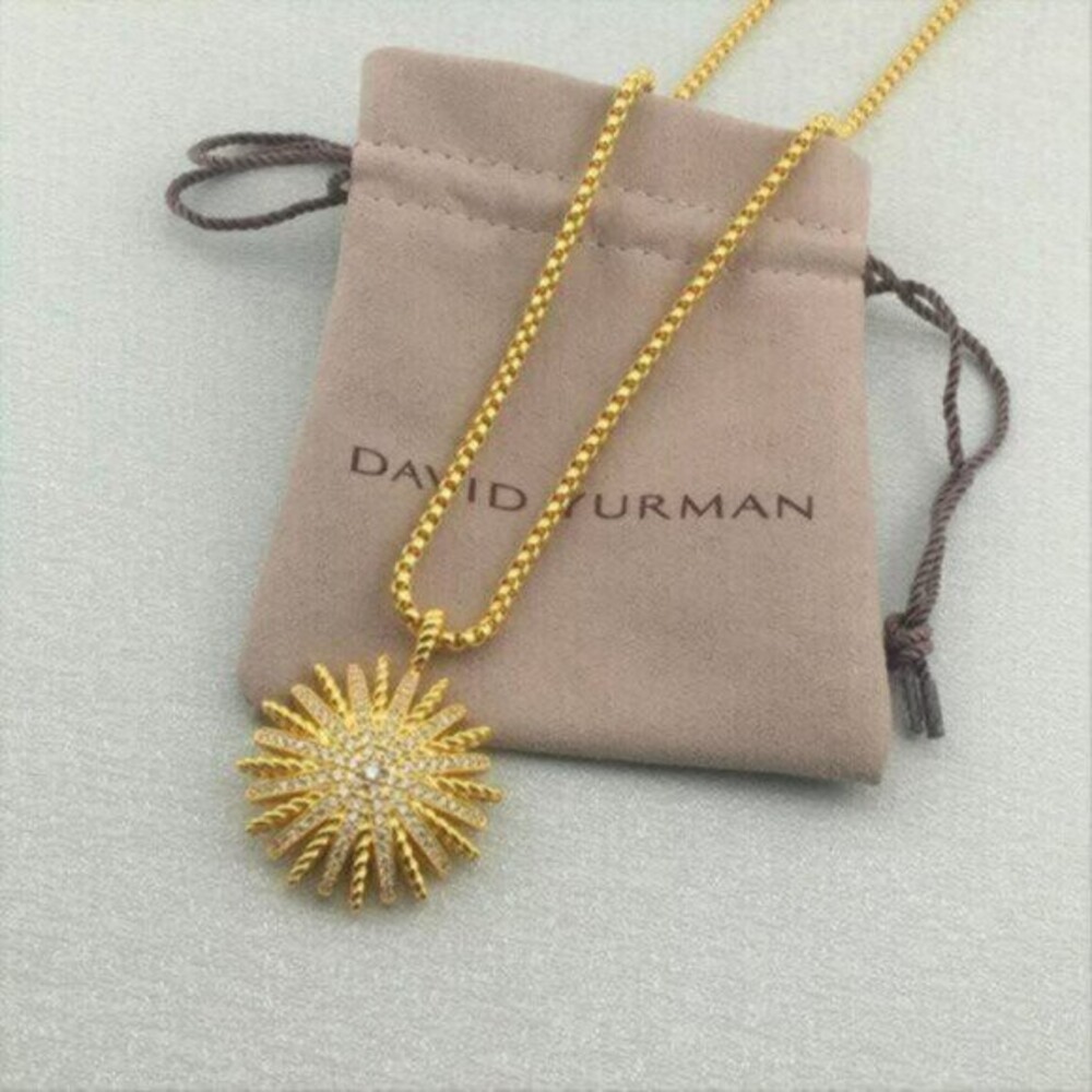 An 18K gold & diamond starburst pendant on 18 inch yellow gold chain